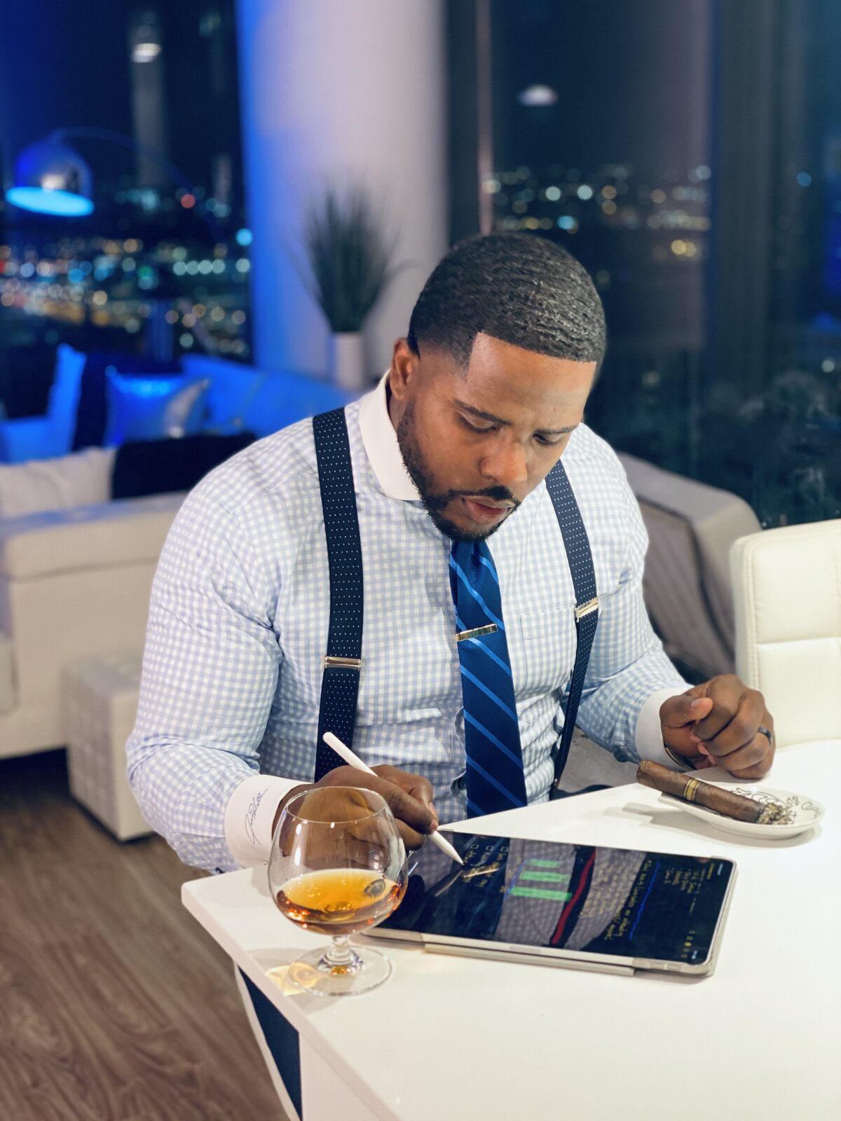 Isiah Williams marking up a chart on a tablet at night above the city skyline