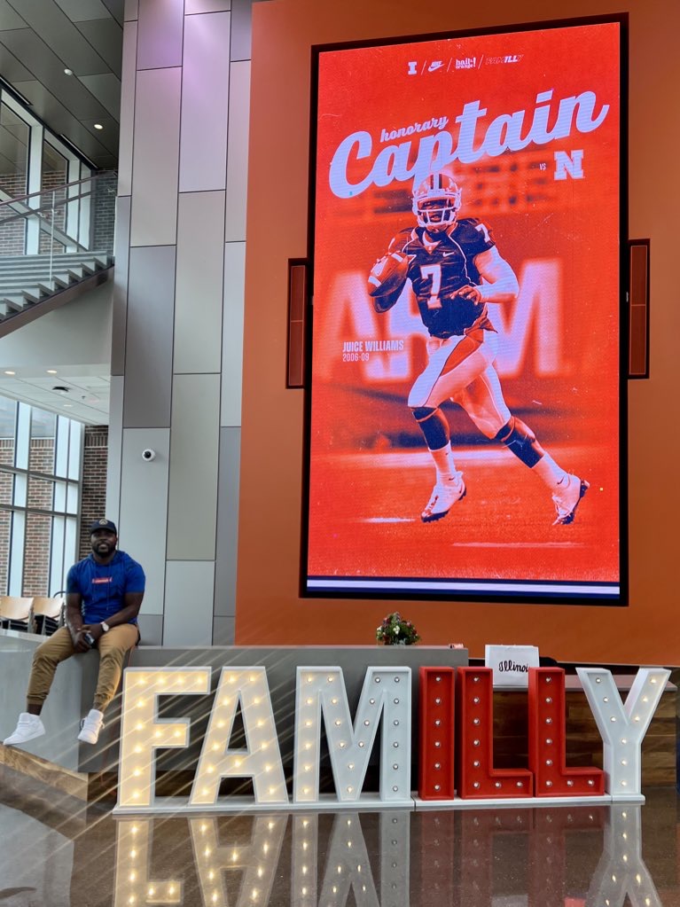 Isiah Williams beside an Illinois honorary captain display featuring his quarterback photo