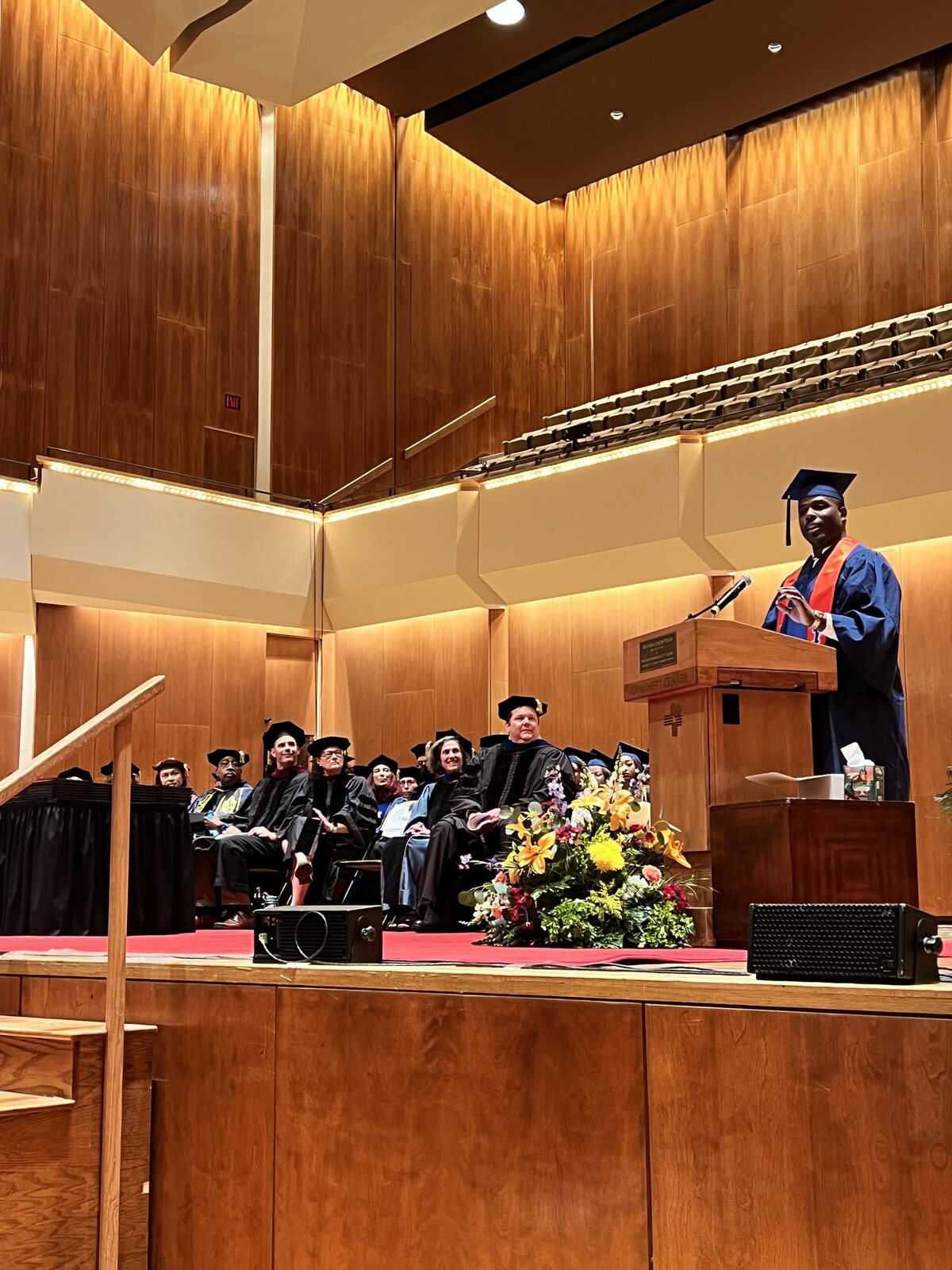 Isiah Williams delivering a commencement address from the podium